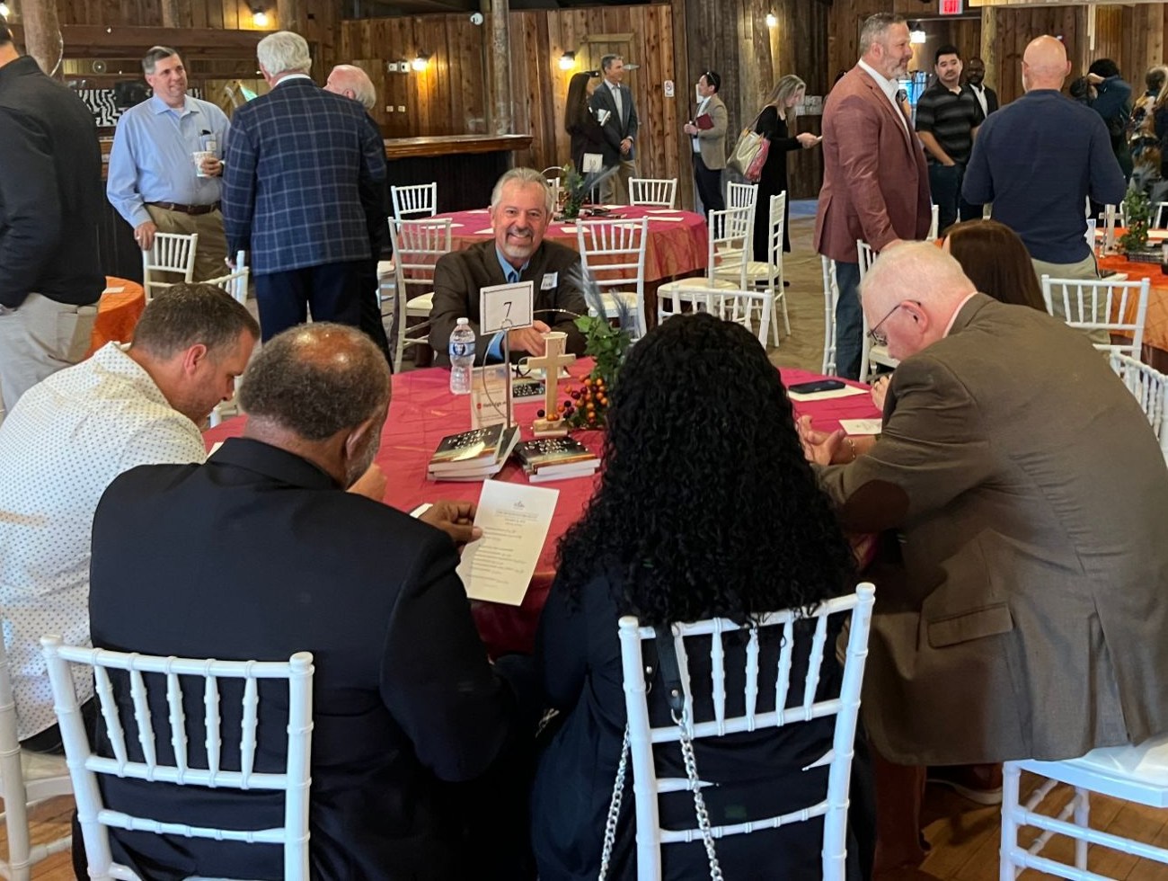 A table of guests praying together at the 2025 Fort Bend Prayer Breakfast
